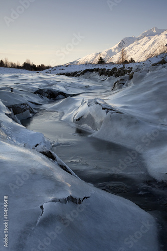 Icy Stream Bank in Cold Mountain Landscape 