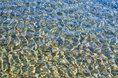 The water in the pool has a tile bottom tile glittering in the sun. Background, texture