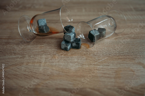 Stones for cooling whiskey and glases tulup on light wooden background photo