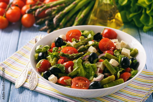 Vegetable salad with asparagus, tomatoes, feta cheese and olives.