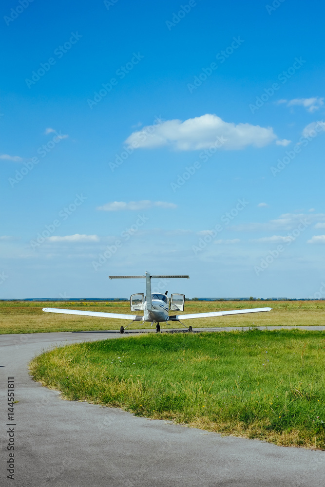 Fototapeta premium Gray airplane parked on the grass at the airfield