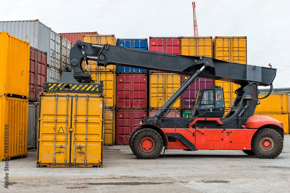Mobile stacker handler in action at a container terminal.