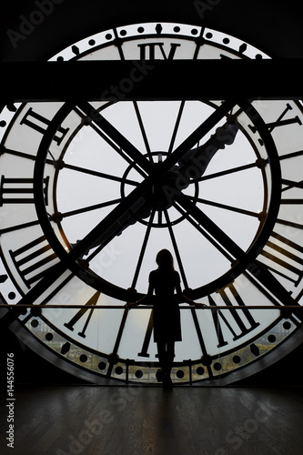 Photos Woman silhouette standing in front of large clock