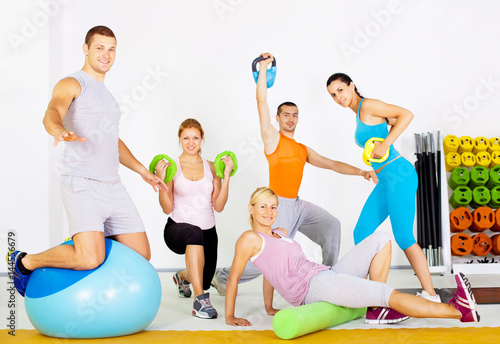 Group of people with exercise equipment at the gym.
