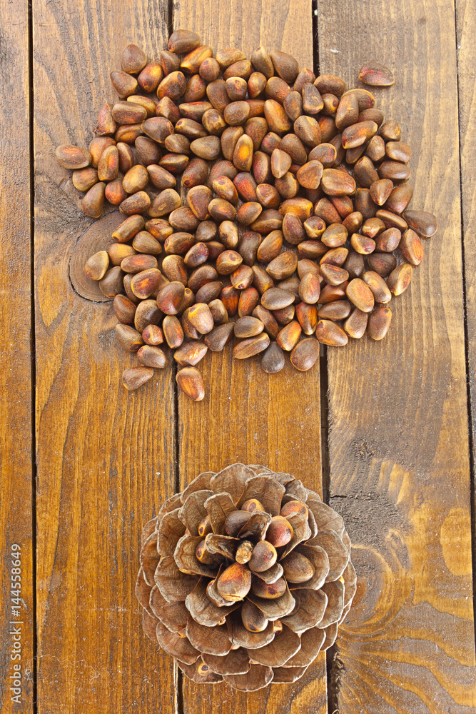 pine nuts and pine cone on wooden table pine nuts and pine cone on wooden table