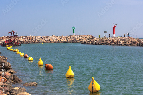 Green and red lighthouses on marine cape and yellow Buoys. Port Saplaya, Valencia, Spain.