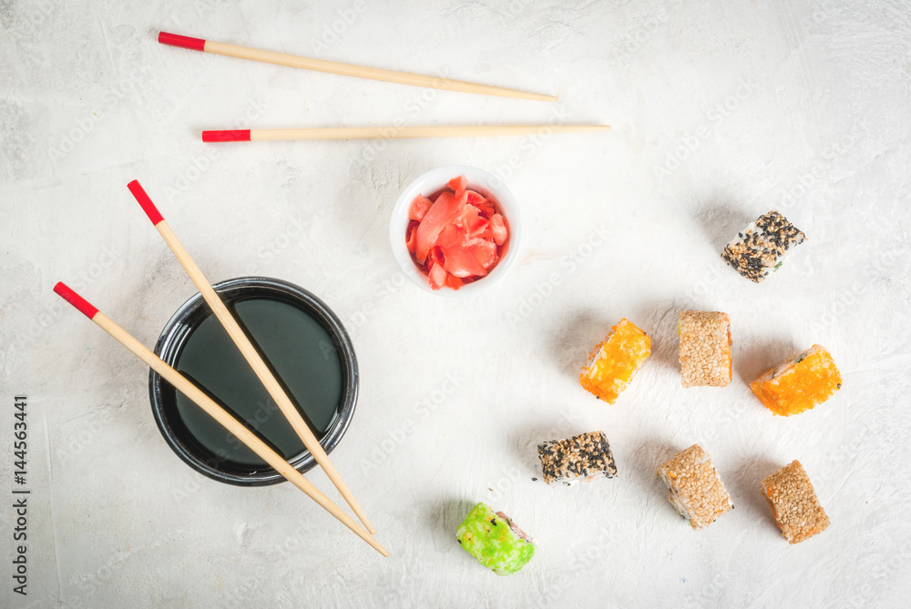 Concept of Japanese food: sticks and sushi, soy sauce and pickled ginger on a black slate stone table. Top view copy space Concept of Japanese food: sticks and sushi, soy sauce and pickled ginger on a black slate stone table. Top view copy space
