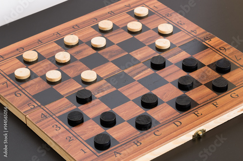 Scacchi e pedine dama  fotografati su una scacchiera