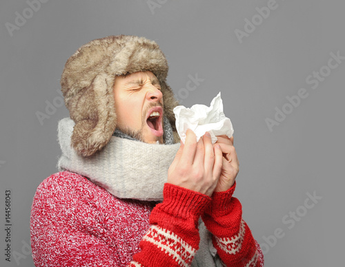 Young ill man on grey backg...