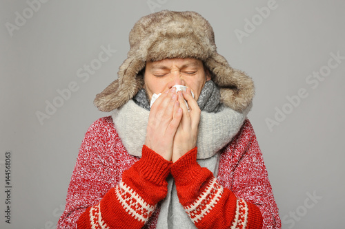 Young ill man on grey backg...