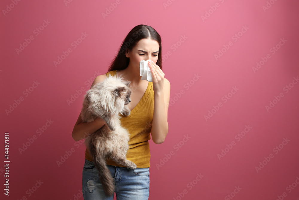 Animal allergy concept. Beautiful woman with cat on color background