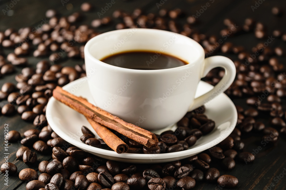 Obraz premium coffee cup bean and cinnamon on black wood.