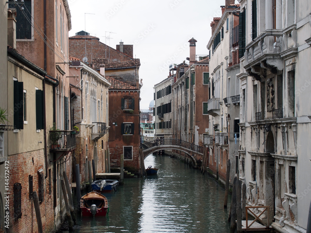 A canal in venice with moored boats and old buildings