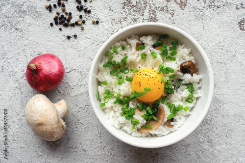 Fotografie Hot white rice with raw yolk, mushroom and green onion