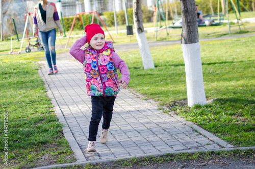 Little girl running along path in the park