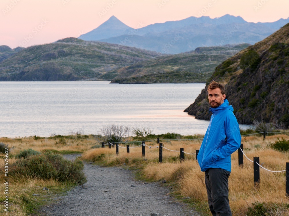 Fototapeta premium Man looking down gravel road to a lake