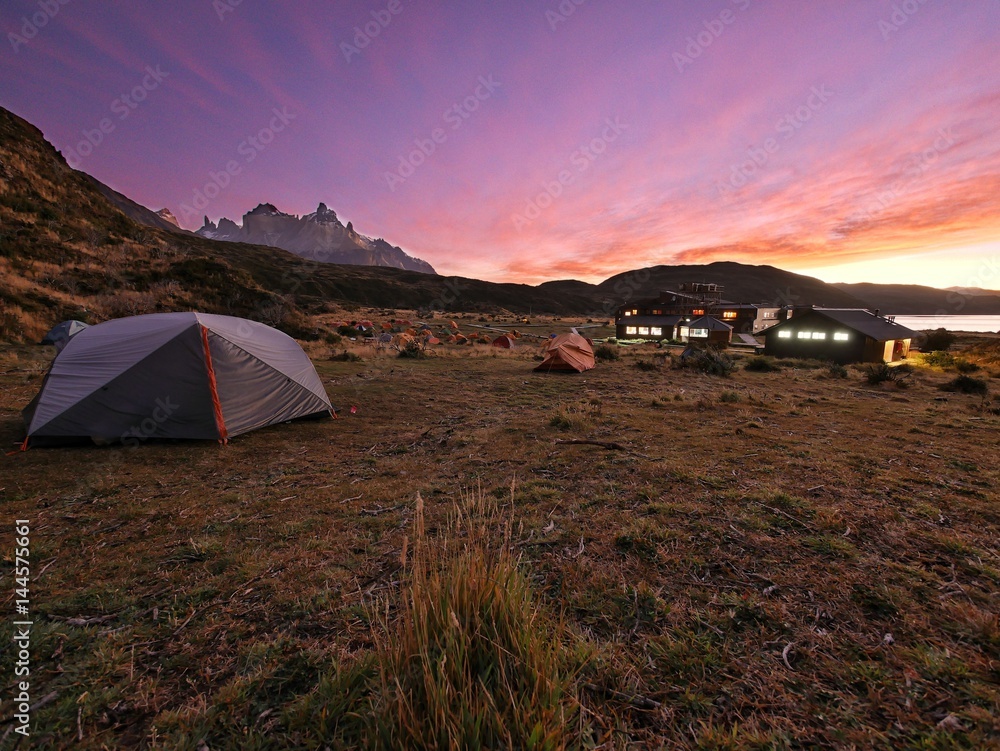 Beautiful orange cloudy sunrise over campsite Torres Paine Grade at Torres del Paine Nationalpark