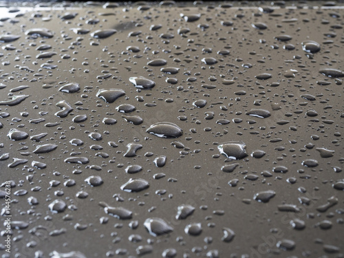 closeup to water drops on car metallic surface with lighting background