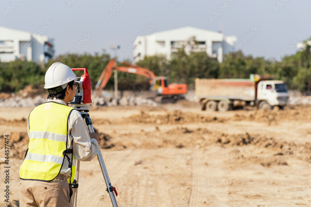 Civil Engineers At Construction Site and A land surveyor using an altometer Civil Engineers At Construction Site and A land surveyor using an altometer
