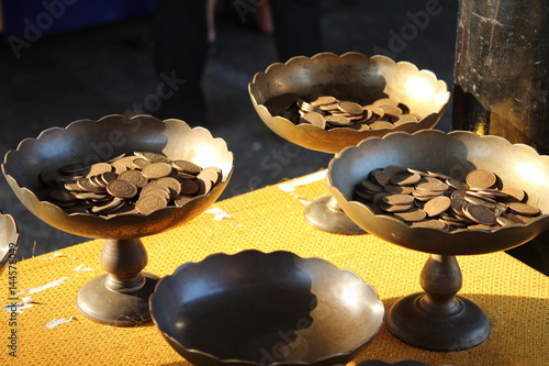 Offering Coins inside Metal Bowls at the Giant Buddha in Thailand