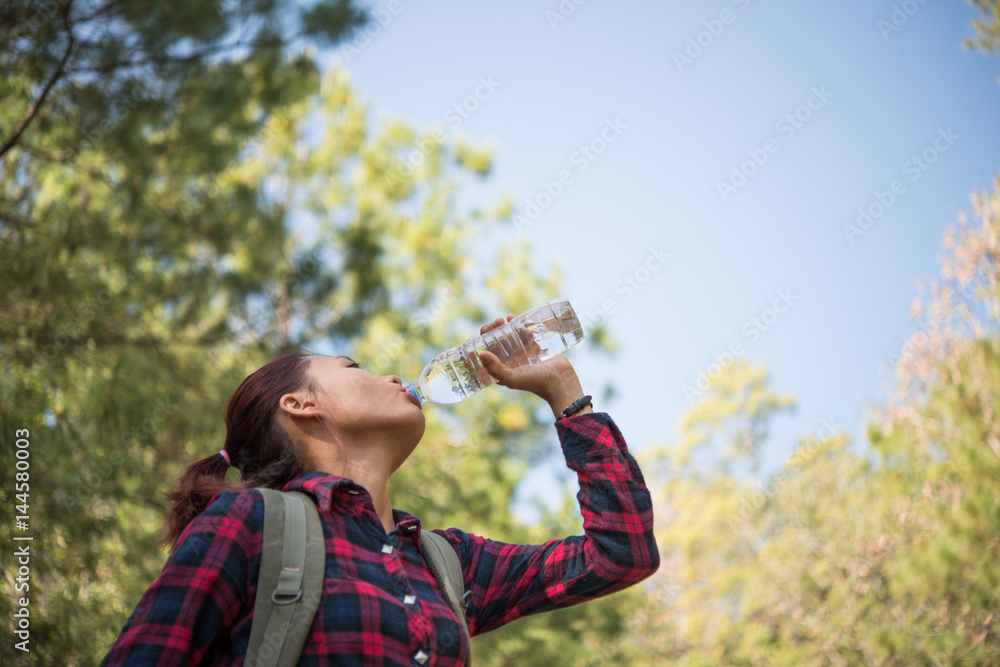 Happy woman tourist with backpack drinking water in nature. Happy woman tourist with backpack drinking water in nature.