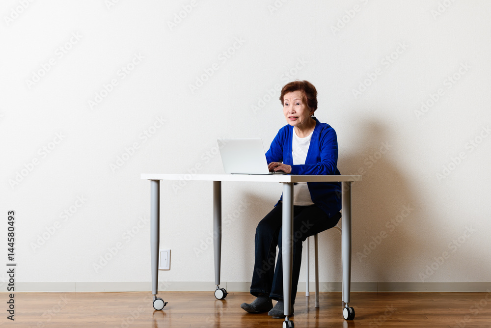 パソコンを使っている高齢のアジア人女性