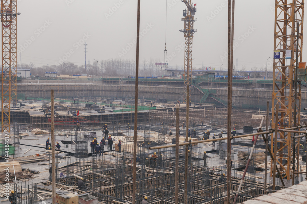 18 Dec,2014 Beijing. Work activity on a construction site in City with cranes and workers,building train station