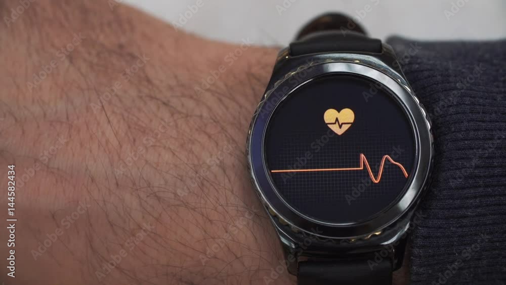 Smartwatch showing the heart rate to the user. The watch is on his right hand