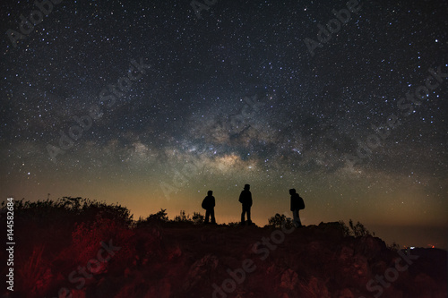 Landscape with milky way  Night sky with stars and silhouette of a standing man on Doi Luang Chiang Dao mountain  Long exposure photograph  with grain