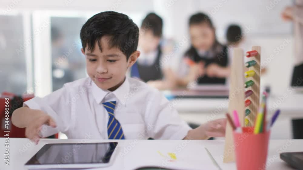 Young school children in class with little boy using abacus & computer tablet Young school children in class with little boy using abacus & computer tablet