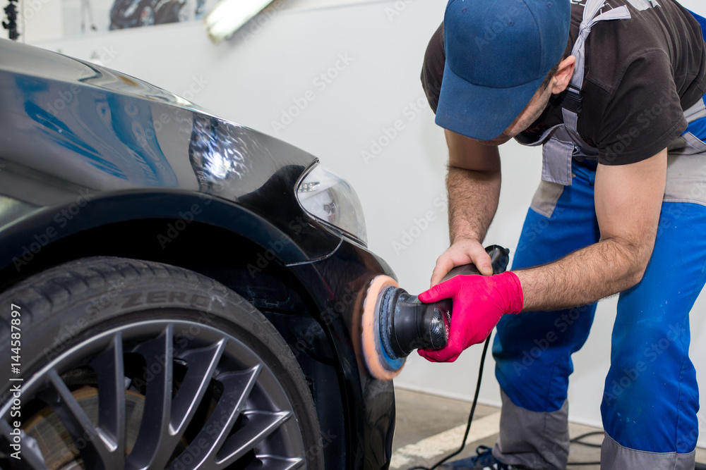 A man polishes a black car A man polishes a black car