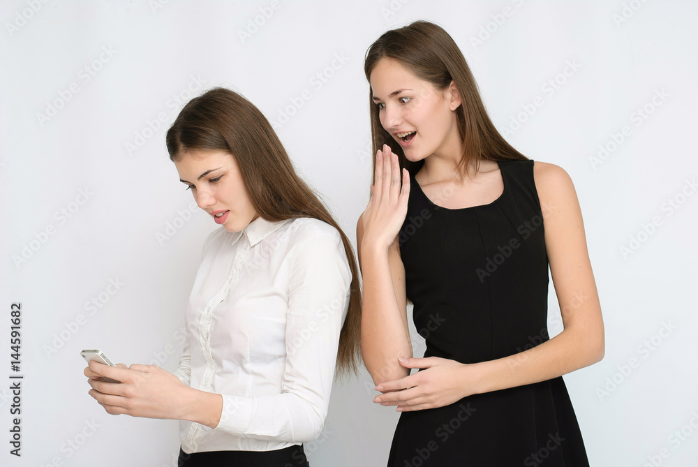 Woman looking sideways her friend phone mobile and spy what message writing Woman looking sideways her friend phone mobile and spy what message writing