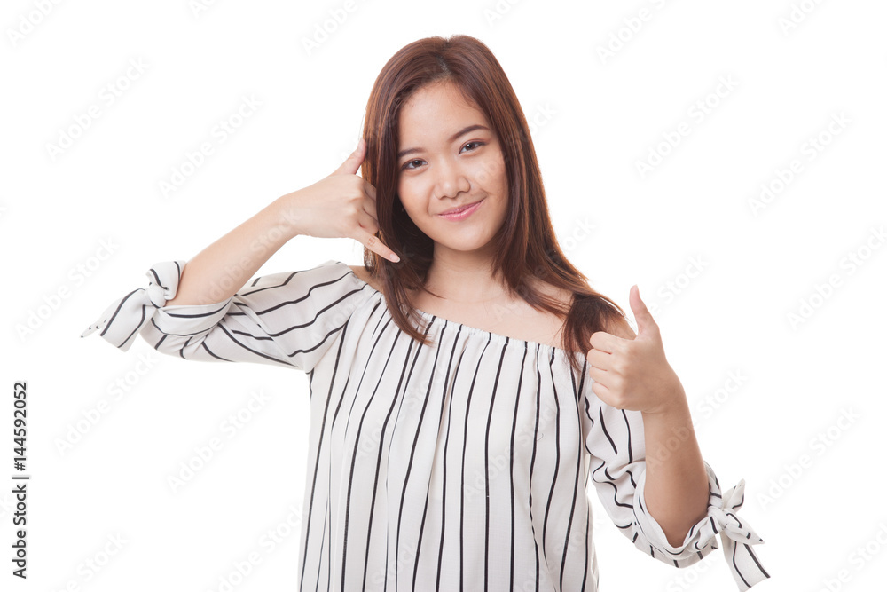 Young Asian woman thumbs up show with phone gesture. Young Asian woman thumbs up show with phone gesture.