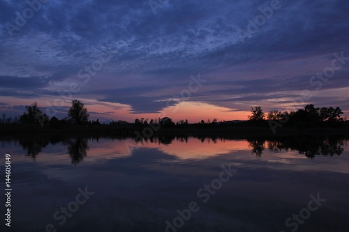 Sunset scene in Auslikon. Colorful sky reflecting in lake Pfaffikon. photo