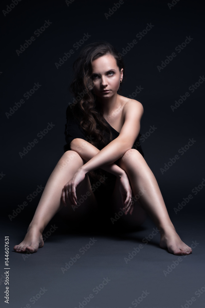 Young beautiful girl poses sexually on a black background Young beautiful girl poses sexually on a black background