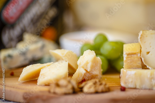 Photos Different types of Italian cheeses (Parmesan, Gorgonzola, Roquefort) are on the Board