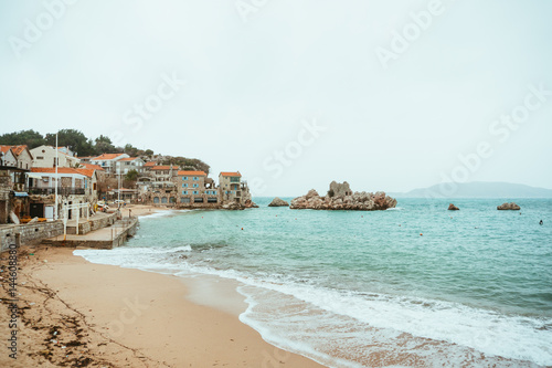 Przno, Montenegro. Beach, sun beds and umbrellas on the beach, the beach line.