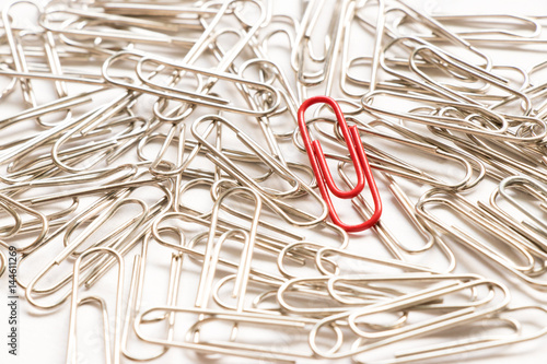 Canvas Print Red paper clip show different from the others on white background