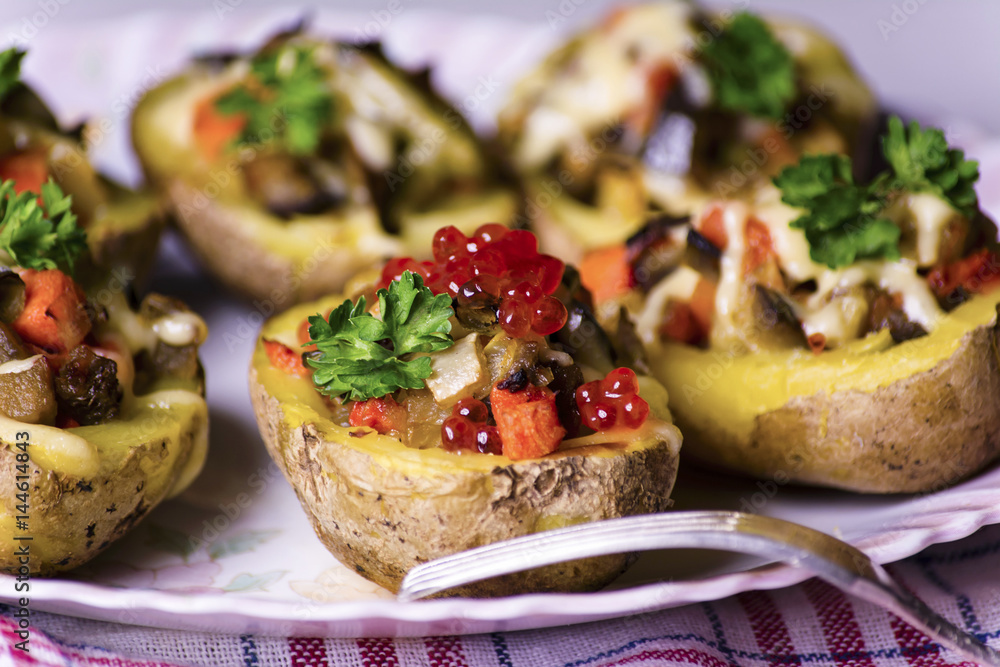 Baked potatoes stuffed with vegetables and red caviar