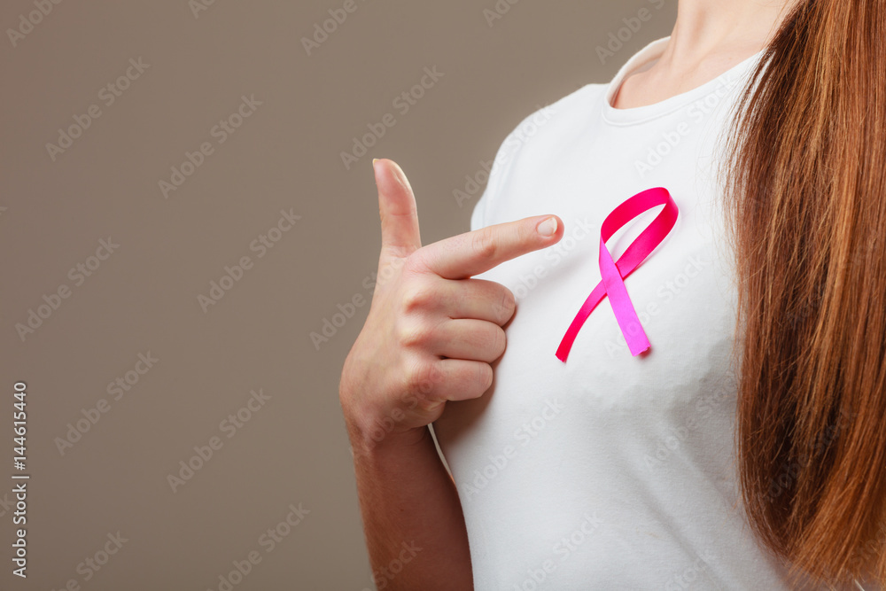 Pink ribbon on woman chest to support breast cancer cause Pink ribbon on woman chest to support breast cancer cause