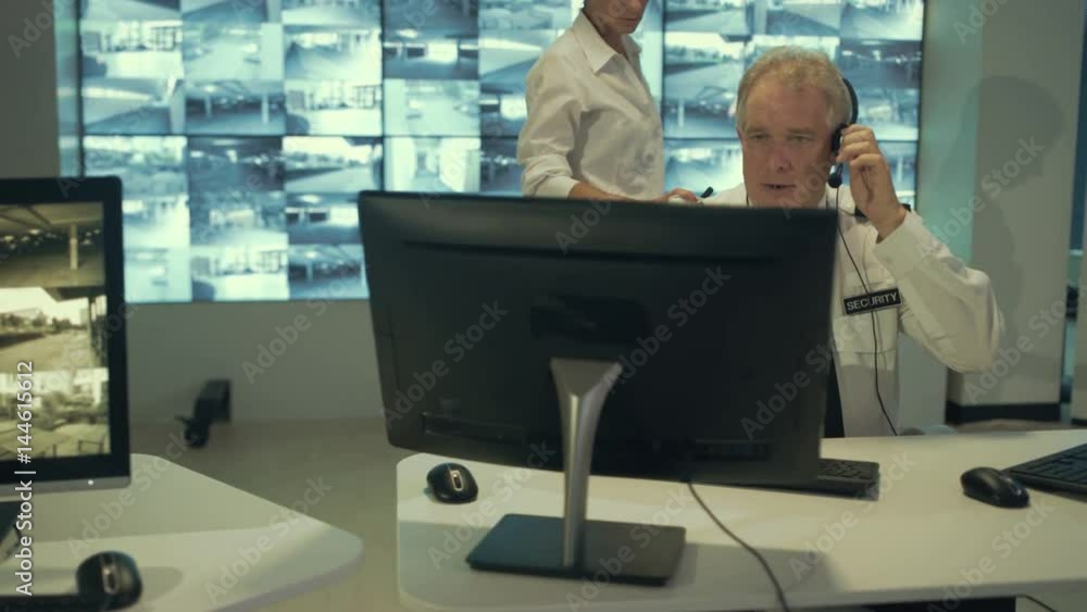 Stressed out security guard working with colleagues in observation control room. Stressed out security guard working with colleagues in observation control room.