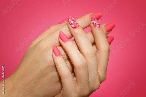 Manicured woman s nails with pink nailart with flowers.
