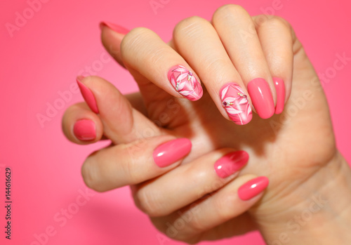 Manicured woman's nails with pink nailart with flowers. photo