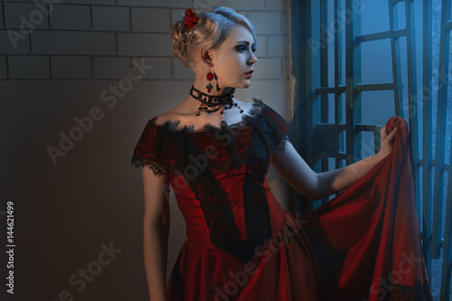 Φωτογραφία Beautiful woman in a Victorian style, wearing a lush red dress and ornaments