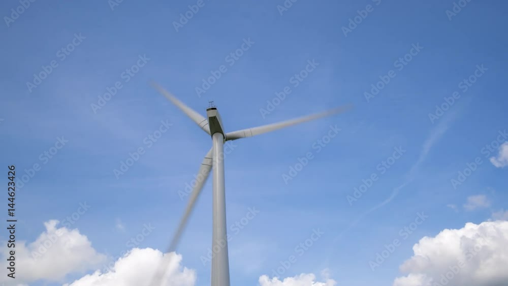 Wind Turbine Time Lapse 4K Clouds rush across a blue sky background Wind Turbine Time Lapse 4K Clouds rush across a blue sky background