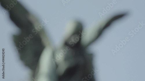 Old tombstone from 20th century with an angel on a sunny spring day. Defocus from angel. 4K in SLOG3. Close up.