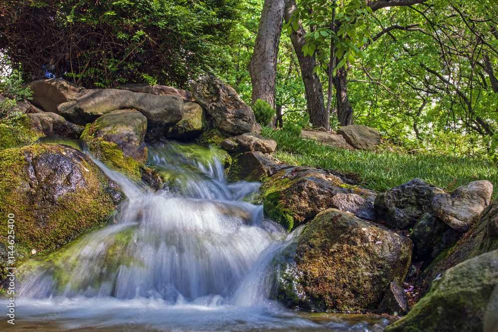 Small artificial waterfall in a public park Small artificial waterfall in a public park