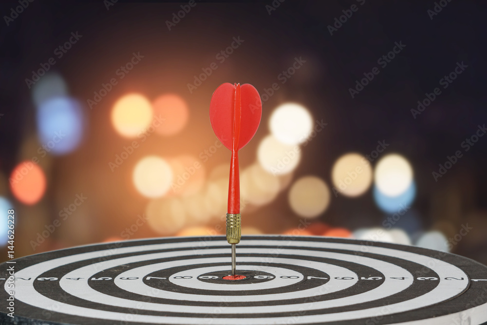target dart with arrow over blurred bokeh background ,metaphor to target marketing or target arrow concept. target dart with arrow over blurred bokeh background ,metaphor to target marketing or target arrow concept.