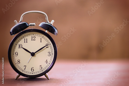 Old fashioned alarm clock with copy space on a blurred background