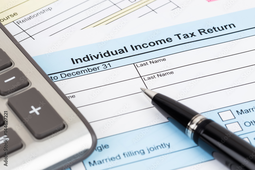 Tax form with pen and calculator; document are mock-up Tax form with pen and calculator; document are mock-up